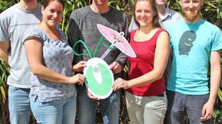 Die beteiligten Wissenschaftler aus Münster mit einem symbolischen Modell ihres Forschungsobjektes - einer Algenzelle mit Sonnenschirm. V. l.: Philipp Gäbelein, Ana Karina Hochmal, Michael Hippler, Karen Zinzius, Martin Scholz und Stefan Schulze; Christian Fufezan fehlt auf dem Foto. (WWU / AG Hippler)