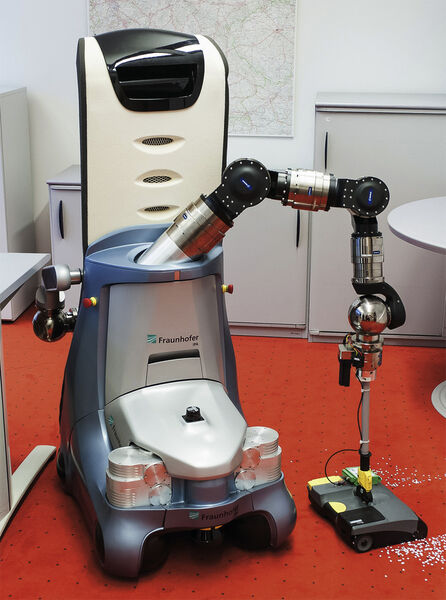 Care-O-bot® erkennt mit seinen Sensoren den Schmutz und entfernt ihn mithilfe eines speziell angepassten Akkusaugers. (Bild: Dussmann Group/Ecke)