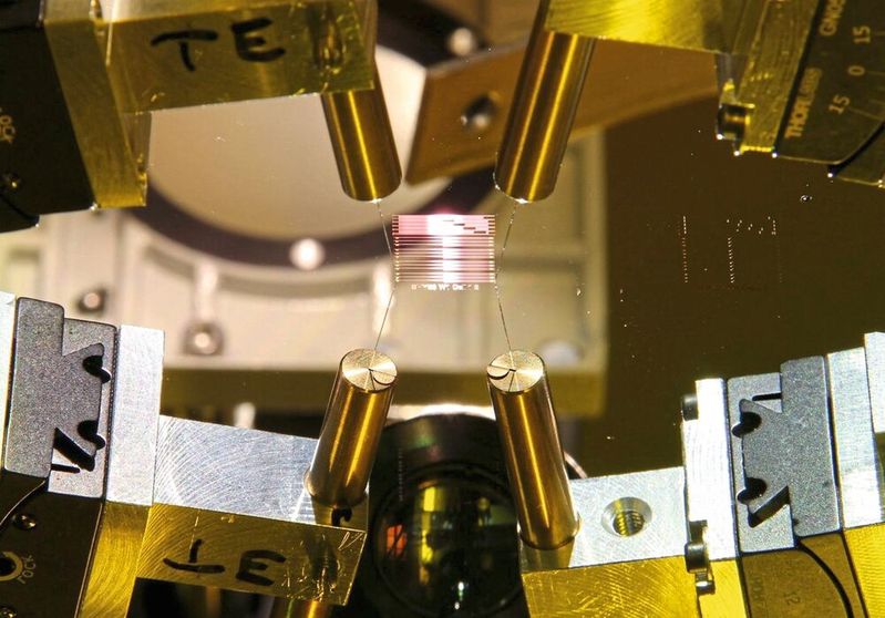 Quantencomputer auf Basis von Ionenfallen: Beispiel für einen integrierten photonischen Chip im Labor-Messaufbau mit Faserkopplung.(Bild:  © AWO GmbH)