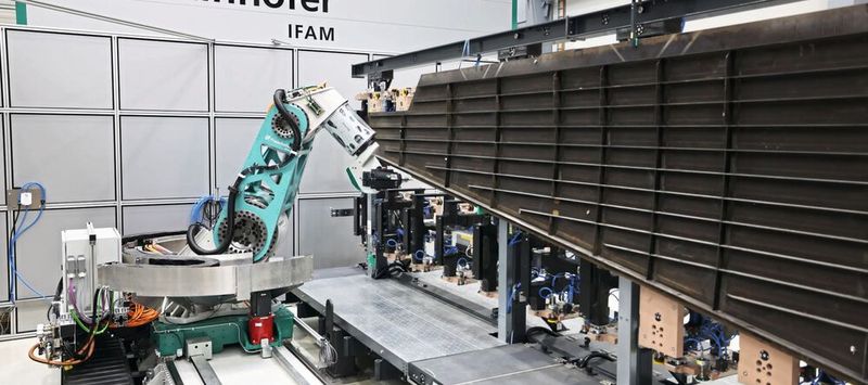 Die neuentwickelte  Fräskinematik mit Hybridantrieb auf einer Linearachse bearbeitet ein CFK-Flugzeugseitenleitwerk im 1:1-Maßstab.(Bild:  Fraunhofer IFAM)