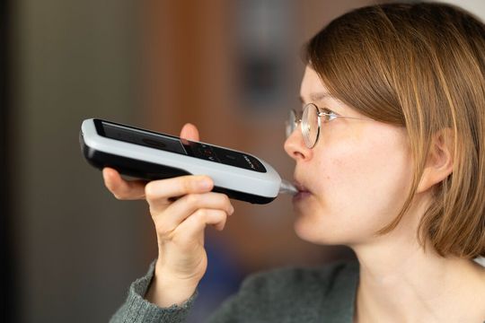 Eine Nutzerin führt mit dem smartphoneunterstützten Aceton-Atemanalysator eine Messung durch.(Bild:  Alivion AG)