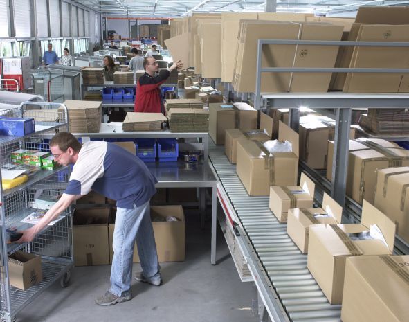 Am Packband wird es knifflig: Welcher Karton eignet sich am besten, um alle Produkte des Auftrages aufzunehmen? Die Profis am Band haben das natürlich im Griff... (Dexx IT)