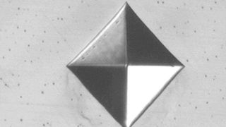 So sieht die Oberfläche eines Stahlbauteils aus, nachdem eine Vickers-Prüfpyramide in das Material eingedrungen ist, um die Härte zu bestimmen. Der Abdruck ist zwar klein, aber doch vorhanden. Koblenzer Forscher setzen jetzt aber auf eine berührungslose Alternative per Laser ... (Bild: KZP)