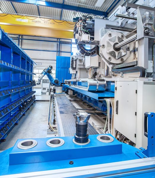 Das automatische Werkzeugwechselsystem samt Kuka-Knickarmroboter KR60 hat Weingärtner platzsparend an der Maschinenrückseite positioniert. Der Roboter bestückt ein Zwischenmagazin, von wo aus der Werkzeugwechsel von Span zu Span immer in weniger als 10 Sekunden erfolgen kann. (Bild: Weingärtner)