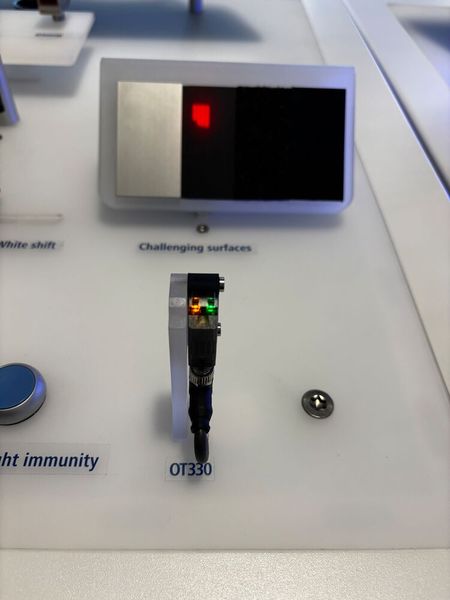Baumer zeigt den OT330 Time of Flight Sensor: Der «OT330» ist ein photoelektrischer Time-of-Flight-Sensor mit Hintergrundausblendung für die zuverlässige Objekterkennung auch unter anspruchsvollen Bedingungen. Dank gepulstem Infrarot-Laser (Laserklasse 1) erreicht der Sensor eine Reichweite von bis zu 2,5 m und überzeugt durch hohe Unempfindlichkeit gegenüber Umgebungslicht sowie zuverlässige Erkennung selbst bei herausfordernden Oberflächen unterschiedlicher Farbe und Reflexion.  (Bild: Jeremy Streiff)