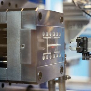 Kunststoffspritzguss mit automatisierter Entnahme: Der Greifer übernimmt die Teile direkt aus dem Werkzeug.(Bild:  Vogt AG Verbindungstechnik)