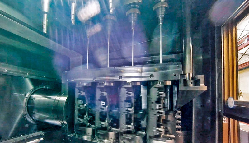 Quadruple machining of fuel-supply distributor parts with deep hole drills. The clamping fixtures that rotate in opposite directions to minimize the deviation of the drill are what makes the solution exceptional. (ELHA)