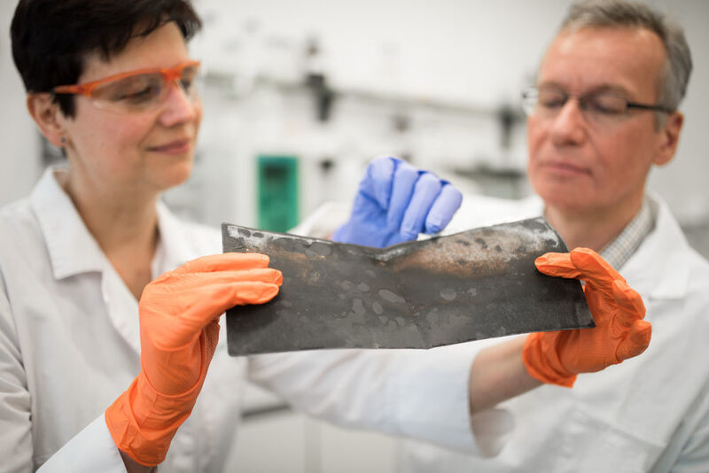 Prof. Jörg Acker und die wissenschaftliche Mitarbeiterin Jana Ducke untersuchen eine Kathodenfolie, die aus einer Lithium-Ionen-Batterie eines Elektroautos nach dessen Demontage entnommen wurde. (BTU Cottbus-Senftenberg)