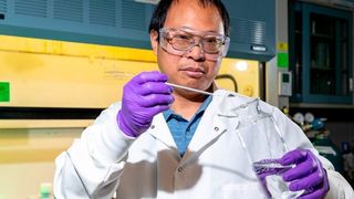 Sandia National Laboratories researcher Guangping Xu adds coal ash into a citric acid mixture. This solution will be fed into a reactor — operating at about 70 times atmospheric pressure — where supercritical carbon dioxide aids citric acid in extracting rare-earth metals. (Rebecca Lynne Gustaf)