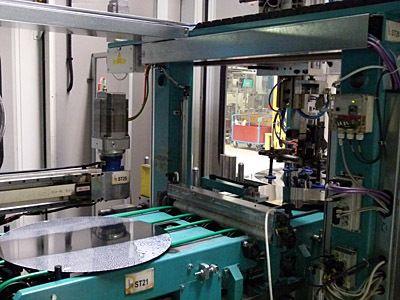 Mit Hilfe einer Vakuumhandhabung werden die Ronden auf einem Feeder der Beölung und des weiteren der jeweiligen Umformpresse zugeführt. (Bild: Kuhn)