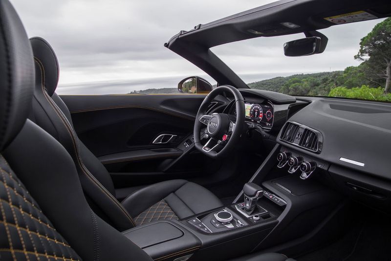 Fahrer und Beifahrer sitzen in einem großzügigen Cockpit, das mit seinem TFT-Bildschirm, dem elektronischen Wählhebel und den technoiden Oberflächen eine ungewöhnlich kühle, futuristische Aura ausstrahlt. (Audi/Daniel Wollstein)