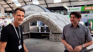 Die Professoren Michael Herrmann und Benjamin Spaeth vor der Beton-Schalenkonstruktion aus 102 3D-gedruckten Elementen, die Studierende unter ihrer Betreuung entwickelt haben. (Bild: TH Lübeck)