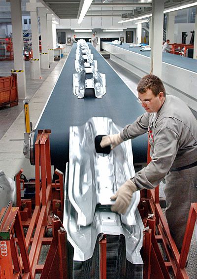 Abstapeln eines Karosserieteils am Förderband der Großraumsauger-Transferpresse (Mitteltunnel Audi A4). (Archiv: Vogel Business Media)