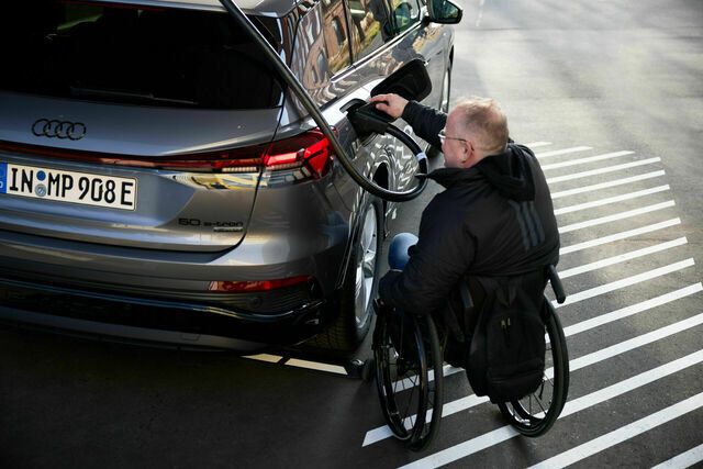 Hilfe für Rollstuhlfahrer: Der Ladestecker wird auf Hüfthöhe aus seinem Steckplatz genommen und zieht sich anschließend selbstständig wieder ein. (Bild: Audi)