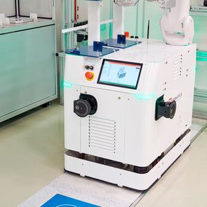 Laden im Prozess: Der mobile Roboter nimmt Energie über ein Ladepanel vor der Handlingstation auf und arbeitet ohne separate Ladepausen weiter. (Bild:  Fabmatics/Sven Claus)