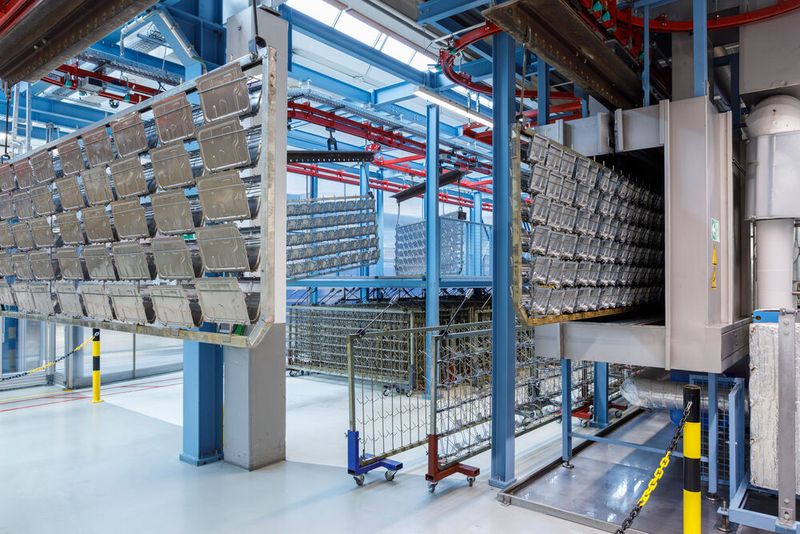 The racks containing the components are transported to the cleaning system via an overhead conveyor. (Image:Yaskawa Europe)