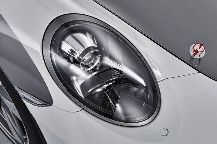 Die Abdeckungen der Hauptscheinwerfer deuten mit klaren und mattierten Flächen ein Kreuz an und erinnern so an eine Besonderheit aus den frühen Motorsportjahren. (Bild: Porsche)