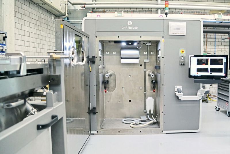 Die DMP 350 Flex bietet eine hohe Wiederholgenauigkeit und hohe Produktivität beim 3D-Druck von Metallteilen – auch bei Materialwechsel. Das Pulverbett (links) kann zum Reinigen komplett aus der Maschine entfernt und ersetzt werden  (Anne Richter, SMM)
