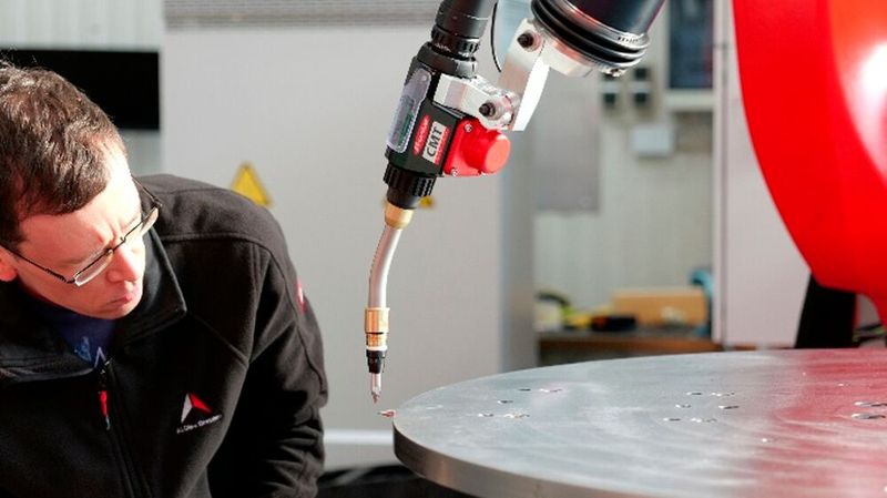 Ein Spezialist ist hier bei der Kalibrierung eines der CMT-Schweißköpfe zu sehen, mit dem die Roboter-WAAM-Anlage von Alotec Dresden Metallteile additiv fertigt. (Bild: Alotec Dresden)