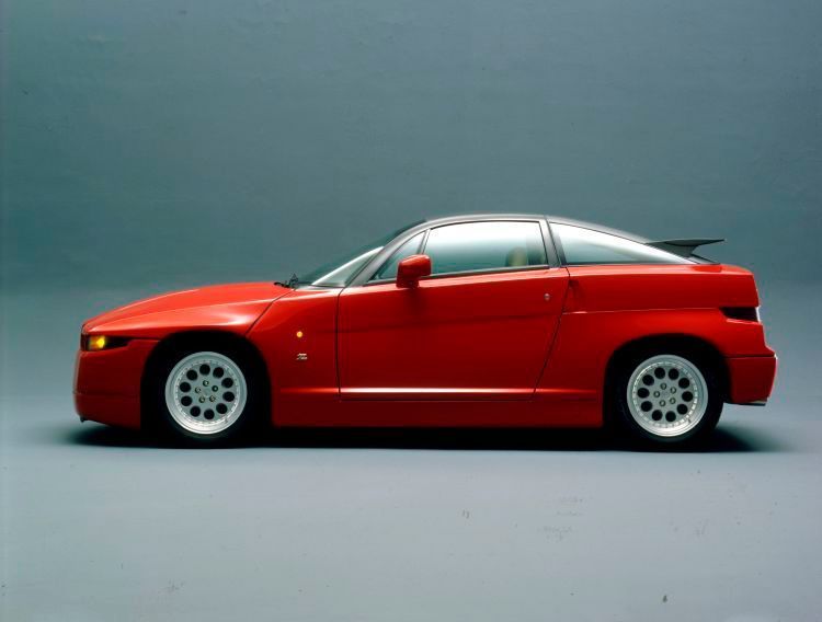 Der Alfa Romeo SZ markierte die Rückkehr der Marke in das Segment der leistungsstarken Sportcoupés. Die Karosserie besteht komplett aus Verbundmaterialien und wurde bei Zagato handgefertigt. Chassis und mechanische Komponenten – inklusive des klassischen Transaxle-Layouts – stammten vom Alfa Romeo 75 3.0 V6. Rund 1.000 Stück des avantgardistischen Coupés wurden gebaut, ausschließlich in „Alfa Rot“ lackiert und zum Preis von mehr als 100 Millionen Lire verkauft. Das von FCA Heritage offerierte Exemplar ist eines der ersten, gebaut am 15. September 1989. Dieser Alfa Romeo SZ wurde auf dem firmeneigenen Testgelände Balocco für Fahrversuche und als Entwicklungsträger eingesetzt. Die technischen Unterschiede zu den späteren Serienfahrzeugen machen ihn beinahe zu einem Prototypen. (FCA)