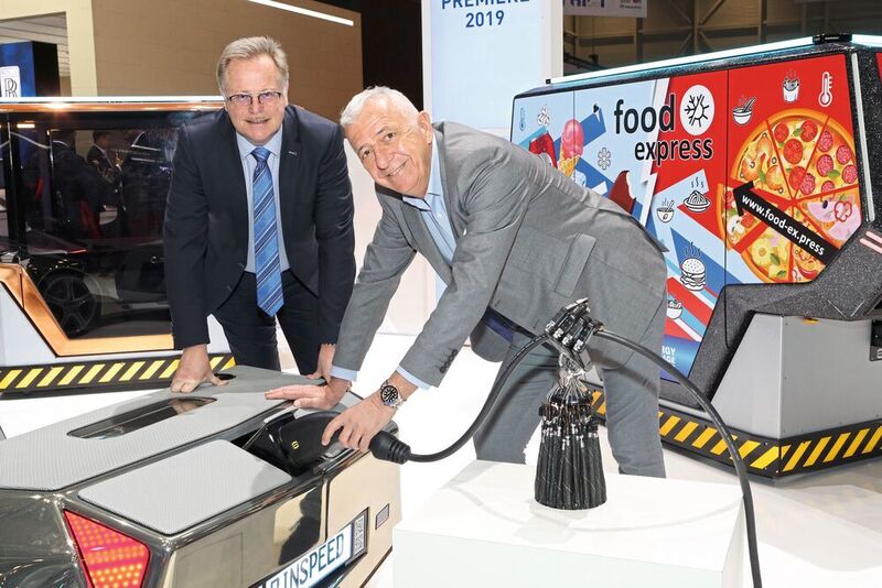 Der Schweizer Autovisionär Frank M. Rinderknecht (rechts) mit Detlef Sieverdingbeck, Zentralbereichsleiter Publizistik und Kommunikation bei der HARTING Technologiegruppe, mit der HARTING Ladetechnik am „microSNAP“ auf dem Autosalon in Genf.  (Harting)