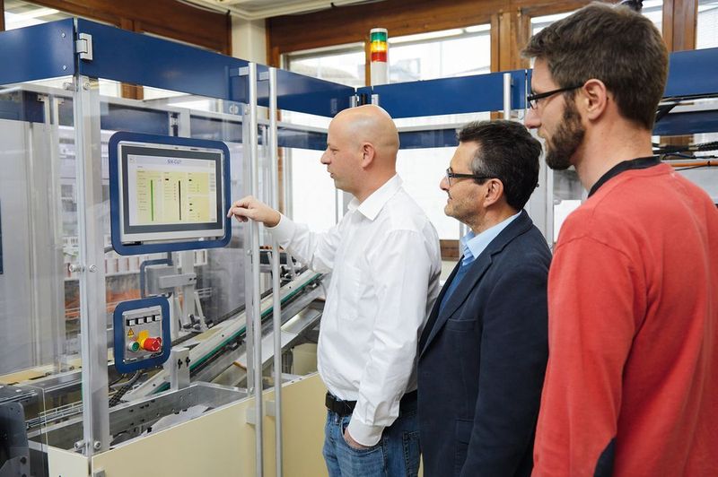Patrick Suter, Bereichsleiter Entwicklung bei Durrer, Robert Urech, Area Salesmanager von Beckhoff Schweiz, und Benedikt Leisibach, Leiter Entwicklung Mechanik bei Durrer (von links) an der Falzbogen-Zuführung für die Schneidemaschine Six-Cut. (Beckhoff)