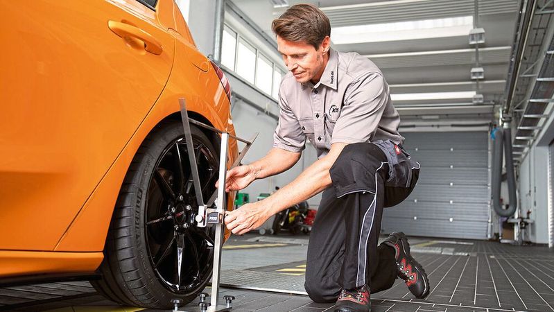 Ein Prüfingenieur überprüft eine Rad-Reifen-Kombination zusammen mit einer Fahrwerksänderung.(Bild:  KÜS)