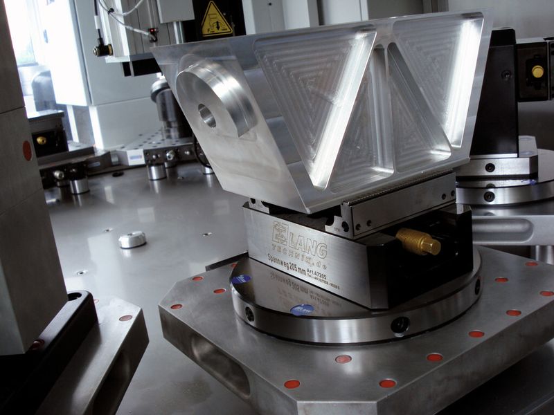 Durch das Vorprägen einer definierten und patentierten Form ausserhalb der Maschine ist der Stillstand der Maschine beim Werkstückwechsel sehr kurz, denn die vorgeprägte Form dient der präzisen Positionierung des Werkstücks mit einer Wiederholgenauigkeit von 0,01 mm ohne Anschläge zu benötigen.  (Bild: Intool AG)
