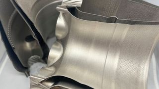 A combustor liner made using Amperprint 0233 Haynes 282 powder from Höganäs. The part features 23,000 unique holes for optimized air-to-fuel ratios and internal channels for regenerative cooling. The part is shown as printed, with no supports. (Business Wire)