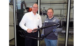 Felix Dorn of Weber Fibertech, right, and Joachim Scheffer of Oerlikon HRS Flow, presenting a frame for the li:on youth bicycle that was injection-molded using water injection technology and Flexflow HRS servo-driven hot runner technology.  (Source: Oerlikon HRS Flow)