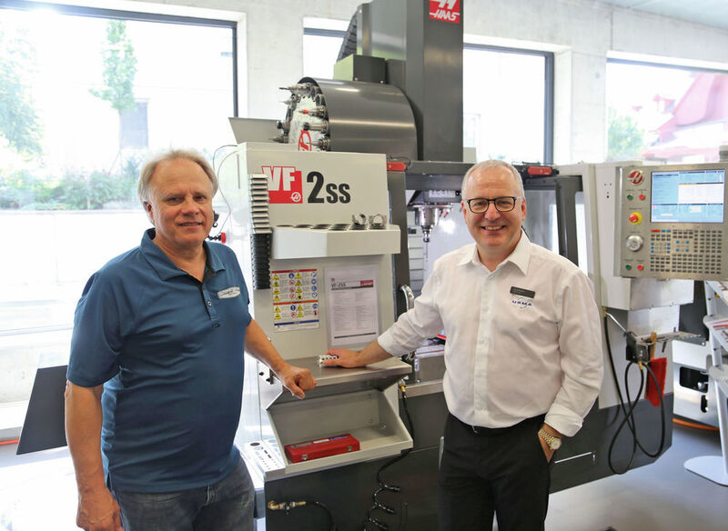 Gene Haas directeur général de Haas Automation Inc, et Urs W. Berner directeur d'Urma AG le distributeur des machines-outils Haas en Suisse (de gauche à droite). En arrière plan le centre d'usinage Haas VF-2SS Super-Speed 762x406x508 mm, 22,4 kW et 12'000 tr/min. (JR Gonthier)