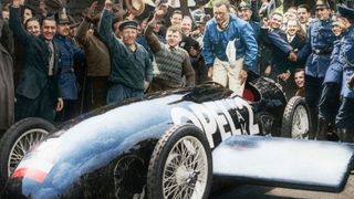 Fritz von Opel wird nach seinem wilden Ritt im RAK 2 gefeiert (Koloration des Schwarz-Weiß-Pressefotos von 1928). (Opel Automobile GmbH)