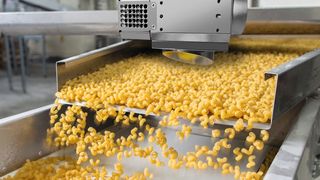 Fig. 1: Il sensore di distanza compatto per nastri trasportatori (in questo caso per la pasta) o scivoli. (Immagine illustrativa) (Immagine: ©Retan - stock.adobe.com)