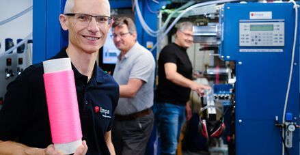 Das Empa-Team von Dr. Rudolf Hufenus, hier vorne, führt auf dem Gebiet der Herstellung von mit Flüssigkeiten gefüllten Fasern. Hier hält der Experte eine Rolle mit den neuen Datenübertragungsfasern mit Flourpolymermantel und Glycerinkern in der Hand. (Bild: Stürmer Foto / Empa)
