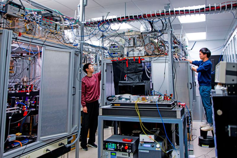 Graduate students Li Du, left, and Yu-Kun Lu adjust the control electronics of the laser systems. (Source: Courtesy of the researchers)