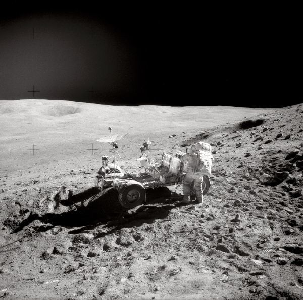 Apollo-16-Kommandant John W. Young beim Verstauen von Werkzeugen im Heck des LRV während der zweiten Apollo-16-EVA. Links hinten zu sehen ist der Smokey Mountain mit seinem großen Krater. (Bild: NASA)