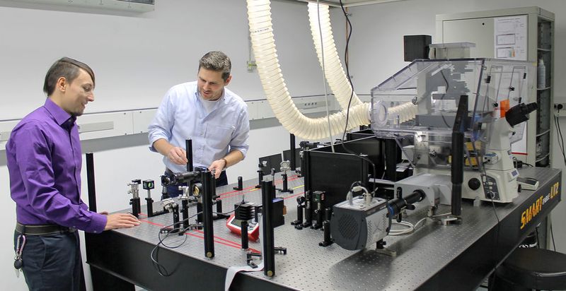 Dipl.-Phys. Steve Keller und Prof. Dr. Holger Kreß (v.l.) bei der Vorbereitung eines Experiments an einem Mikroskop mit einer holographischen optischen Pinzette.  (Christian Wißler)
