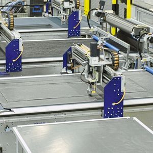 Die Schneidtische, auf denen die Carbonfasern zugeschnitten werden, sind via 6-Achs-Industrieroboter miteinander verkettet.