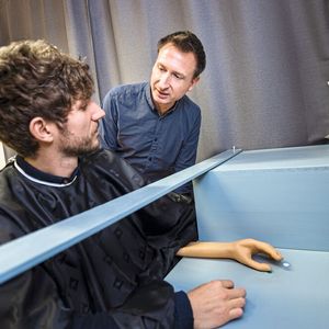 Für die Gummihandillusion legen Versuchspersonen eine Hand in ihr Blickfeld, die andere hinter eine undurchsichtige Wand. Zwischen die beiden Hände wird eine Gummihand platziert.(Bild:  Damian Gorczany, Ruhr-Universität Bochum)