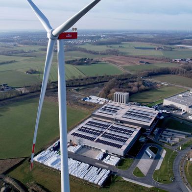 Windenergieanlage und Photovoltaikanlage auf dem Hallendach tragen maßgeblich zur Eigenversorgung des Craemer Kunststoffspritzgießwerks im Gewerbepark Aurea mit grünem Strom bei. (Bild: Craemer)