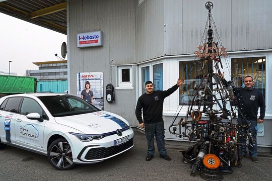 Schön ist der Baum auch ohne Schnee und bei Tageslicht: Obermeister Paulo Rodrigues (rechts) präsentiert mit seinem Azubi Marco Mancino den Weihnachtsbaum. Linus Walter, der mithalf, war krank, als die Aufnahme entstand.(Bild:  Kfz-Innung BHS)