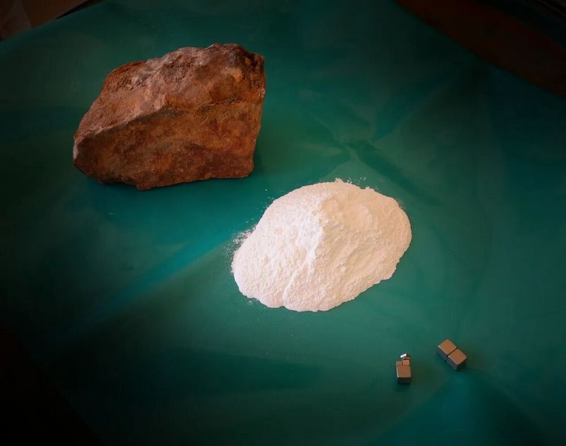 Seltene Erden Karbonat (oben) ist der Rohstoff, in dem sich Seltene Erden, wie Neodym (für starke Magnete, wie hier unten im Bild) oder Cer, verstecken. Thyssenkrupp Materials Trading handelt mit diesem Rohstoff. Jetzt kommen zwei neue Abnehmer hinzu.