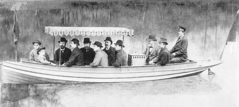 Wilhelm Maybach, Zweiter von rechts, bei einer Fahrt des vom Daimler-Motor angetriebenen Motorboots auf dem Neckar bei Cannstatt im Jahr 1886. Links von Maybach sitzt Gottlieb Daimler.  (Mercedes-Benz AG)