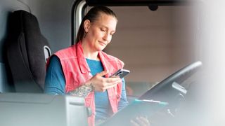 Eine Lkw-Fahrerin bucht eine Mautstrecke mit Toll-Now auf dem Smartphone. (Bild: Toll Collect)