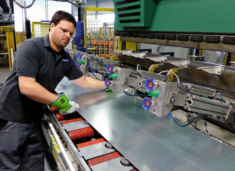 Nach den Einstellungen an der Steuerung kann es mit dem Kanten losgehen. Der Mitarbeiter legt dazu eine Platine auf den Rollentisch der Abkantpresse. (Kuhn)