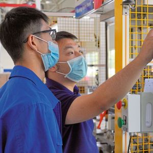 Chen Chuanliang, Prozessingenieur bei Liuzhou AAM, überprüft mit einem Kollegen die Fertigung von Antriebskomponenten mit Hilfe von NC-Fügesystemen von Kistler.