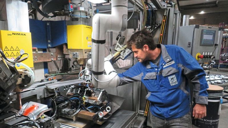 Ein kollaborativer Roboter unterstützt die Mitarbeiter von Meleghy Automotive beim Einlegen von Blechteilen in eine Schweißpresse – sicher, ergonomisch und effizient. So werden Prozessstabilität und Arbeitsergonomie im Fertigungsalltag weiter verbessert. (Bild:  Igus GmbH)