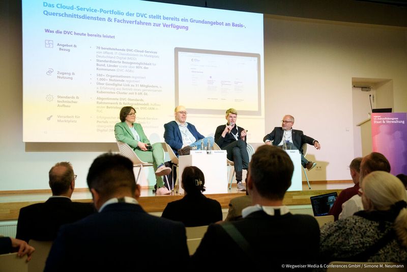 Ein Weg zu neuen digitalen Lösungen führt über den Marktplatz Deutschland Digital. Im Best-Practice-Dialog „DVC – vom Marktplatz zum Ökosystem mit souveräner Betriebsplattform“ stellten Stephan Bartholmei (FITKO), Philipp Gärtner (govdigital eG) und José Gaspar (HZD) den aktuellen Stand und die weiteren Pläne vor (v. l.). Moderation: Simone Conrad (govdigital eG).  (Bild: © Wegweiser Media & Conferences GmbH / Simone M. Neumann)