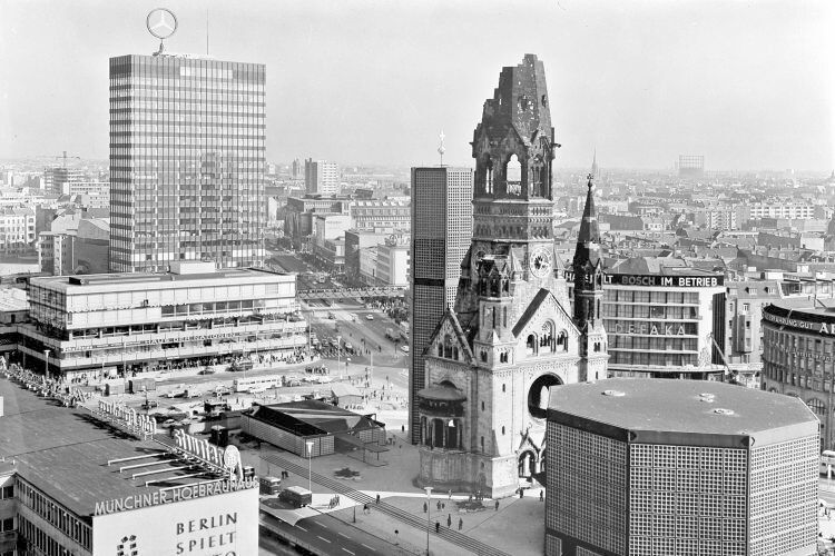 1965 wird ein zehn Meter hoher, drehbarer Mercedes-Stern auf dem Dach des Europa-Centers am Kurfürstendamm in Berlin installiert (links hinten) und am 30. März in Betrieb genommen. Es ist damals die größte drehbare und hydraulisch kippbare Neonanlage der Welt.  (Daimerl AG)