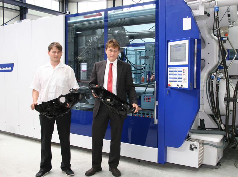 Michael Ullrich (links), technischer Leiter, und Gerald Ullrich, technischer Geschäftsführer bei Plasttechnik Hohleborn, mit einem Teil eines Scheinwerfergehäuses für den Opel Astra Coupe, dem derzeit größten auf der Macro-Power 1000 gefertigten Teil. (Bild: Wittmann Battenfeld)